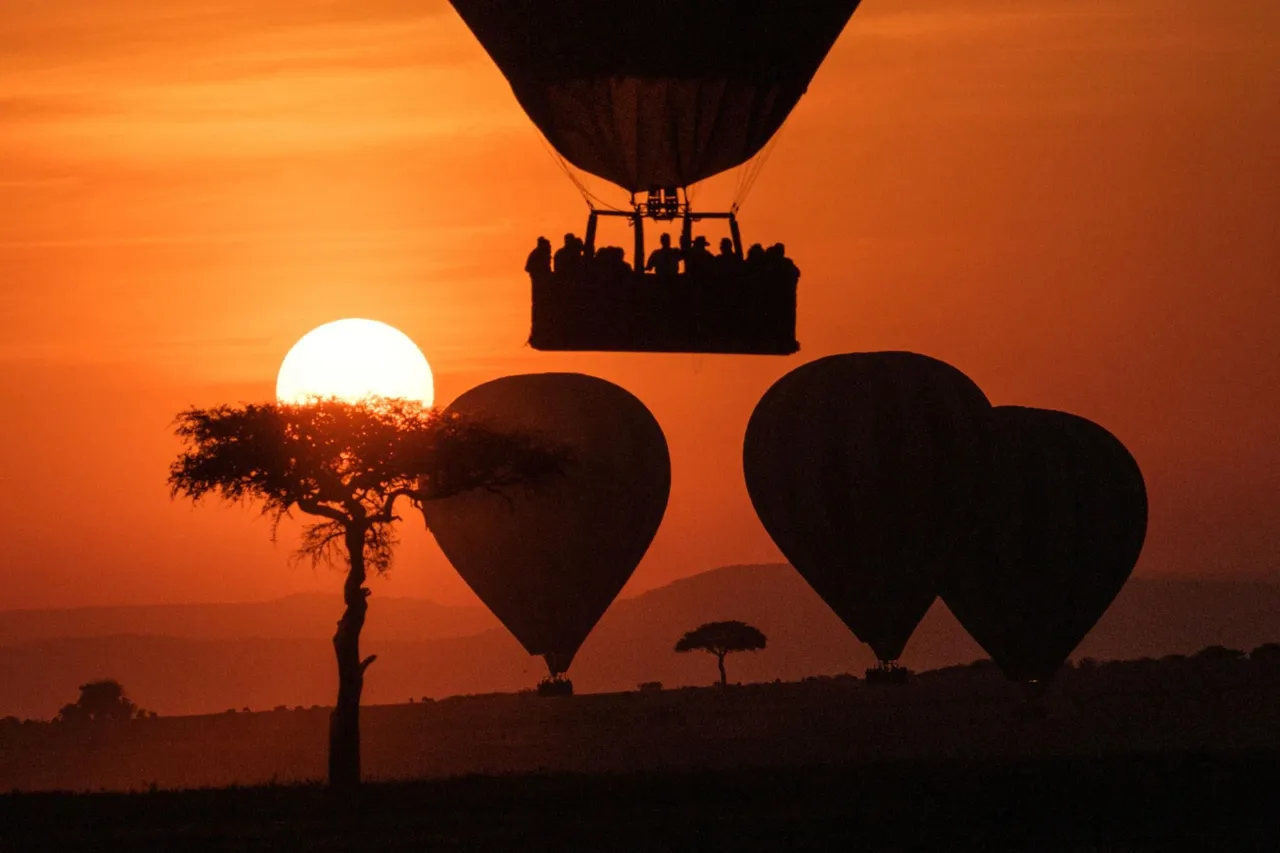 A hot-air balloon floats above the African plains at sunrise, offering an unforgettable bird’s-eye view of the wilderness.